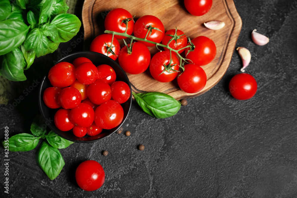 Bowl with canned tomatoes and basil on black background