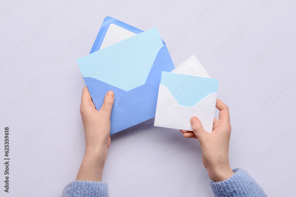 Female hands with envelopes and blank cards on white background, closeup