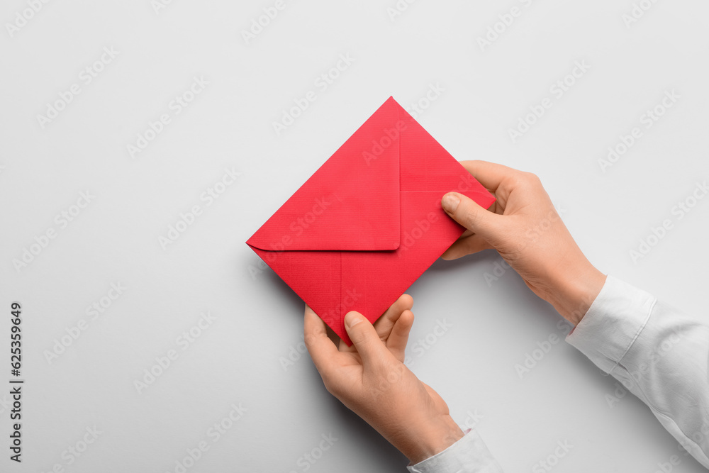 Female hands with red envelope on white background