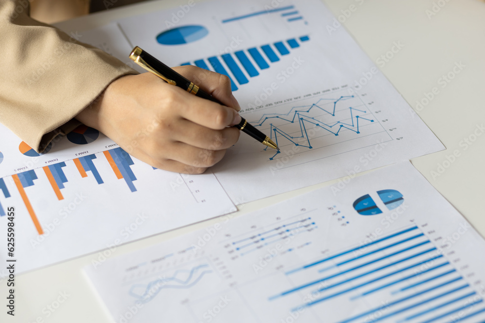 Business woman working on paperwork in the office, analysis of financial charts in business reports.