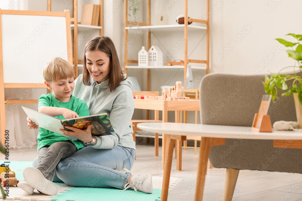 Nanny with little boy reading story at home