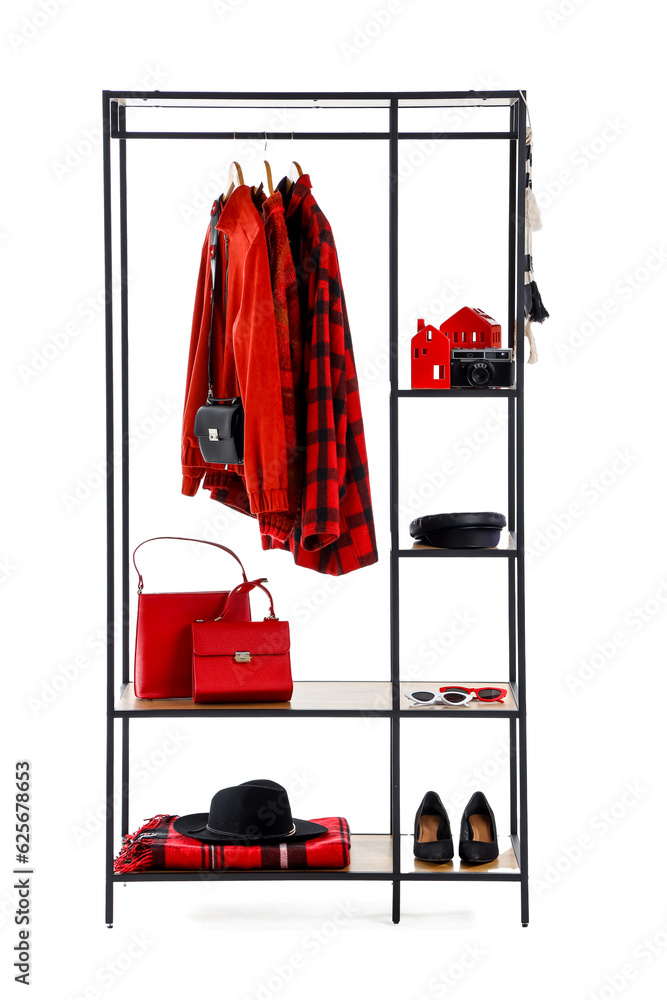 Shelving unit with clothes and accessories on white background