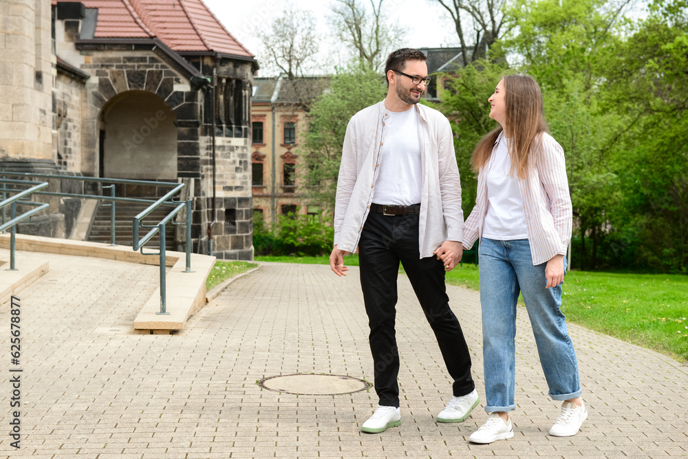 Beautiful happy couple walking in city on spring day