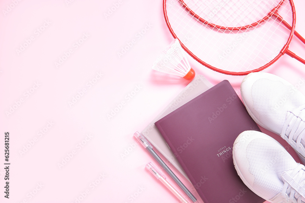 Sneakers with badminton shuttlecock, rackets and stationery on pink background