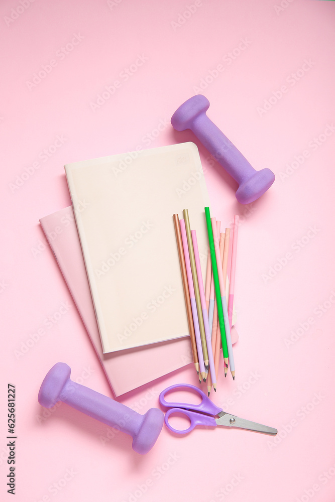 Dumbbells and different stationery on pink background