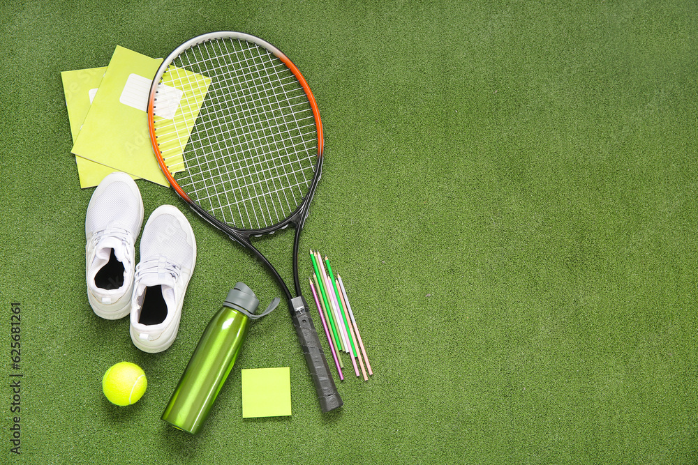 Sneakers with bottle of water, tennis ball, racket and different stationery on color background