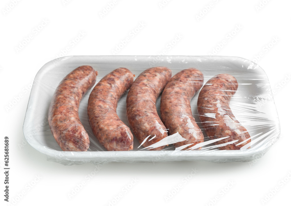 Raw pork sausages in plastic packaging on white background