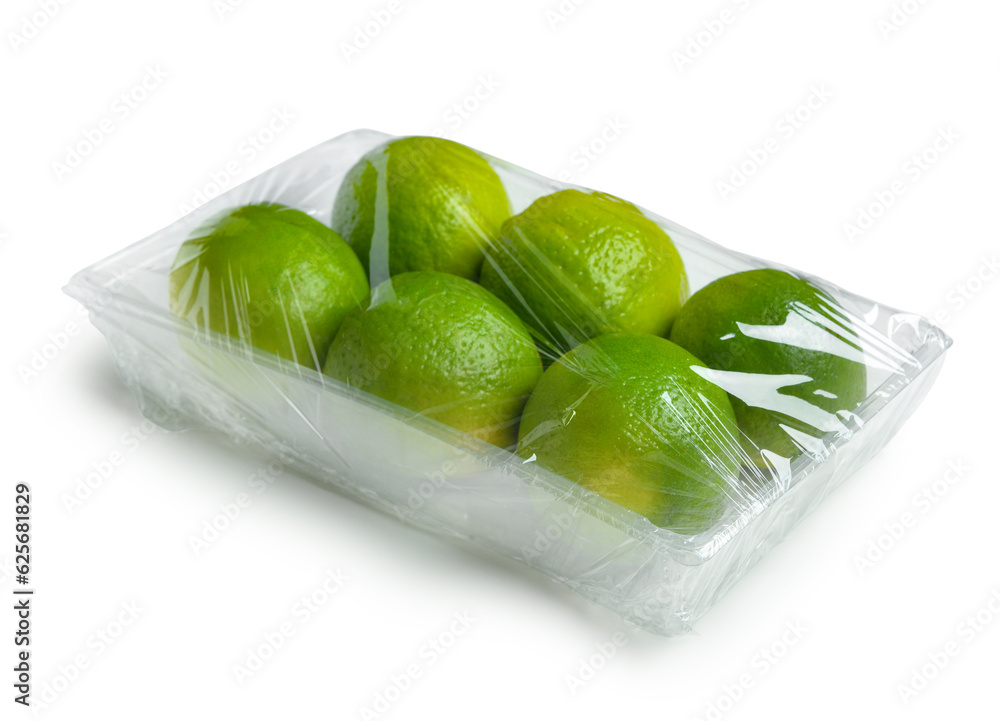 Fresh limes in plastic food wrap on white background