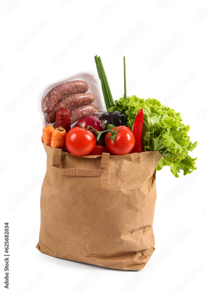 Paper bag with different fresh vegetables and sausages on white background