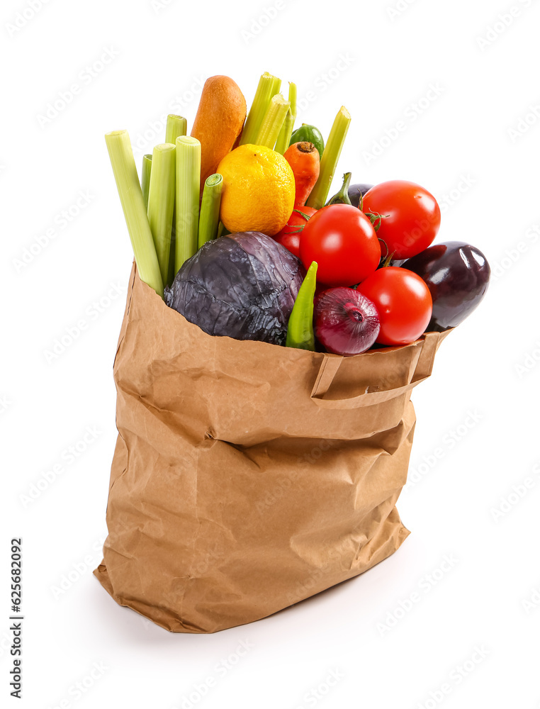 Paper bag full of fresh vegetables and baguette on white background