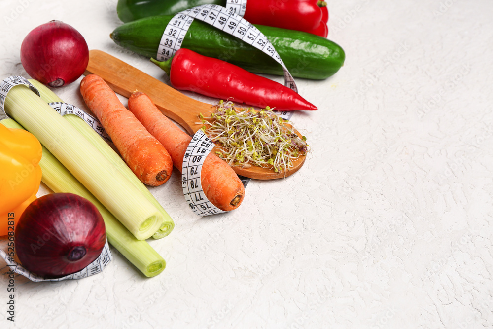 Wooden spoon with microgreen sprouts, fresh vegetables and measuring tape on light background. Diet 