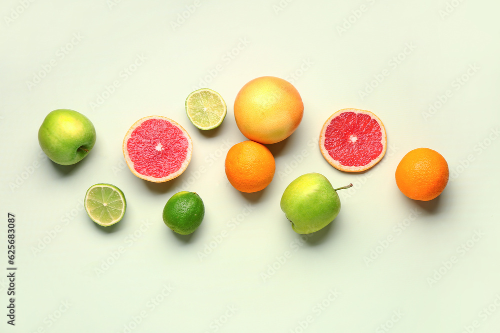 Different fresh fruits on green background