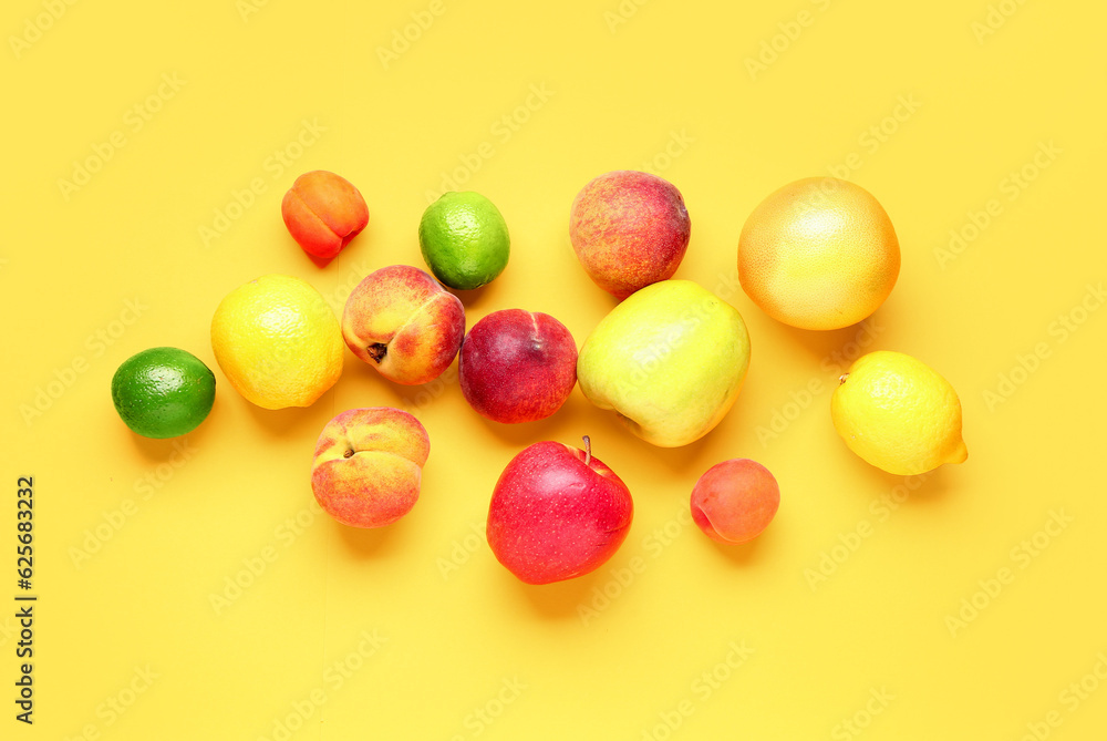 Different fresh fruits on yellow background