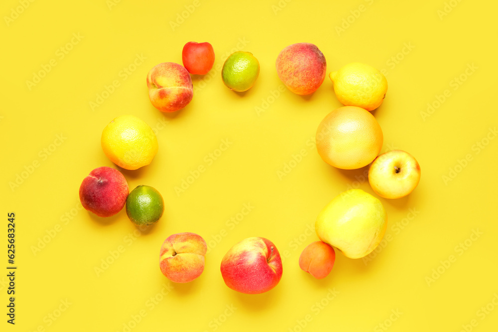 Frame made of different fresh fruits on yellow background