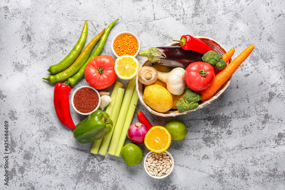 Wicker bowl with different fresh vegetables and cereals on blue background