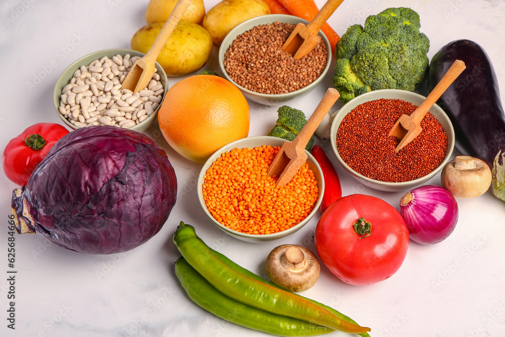 Different fresh vegetables and cereals on white background