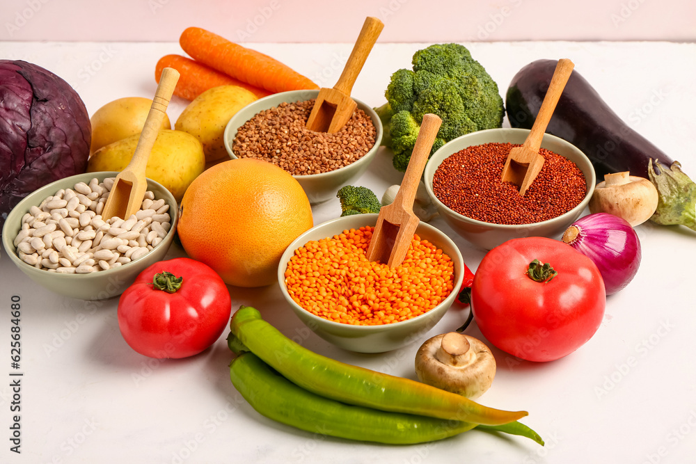 Different fresh vegetables and cereals on white background