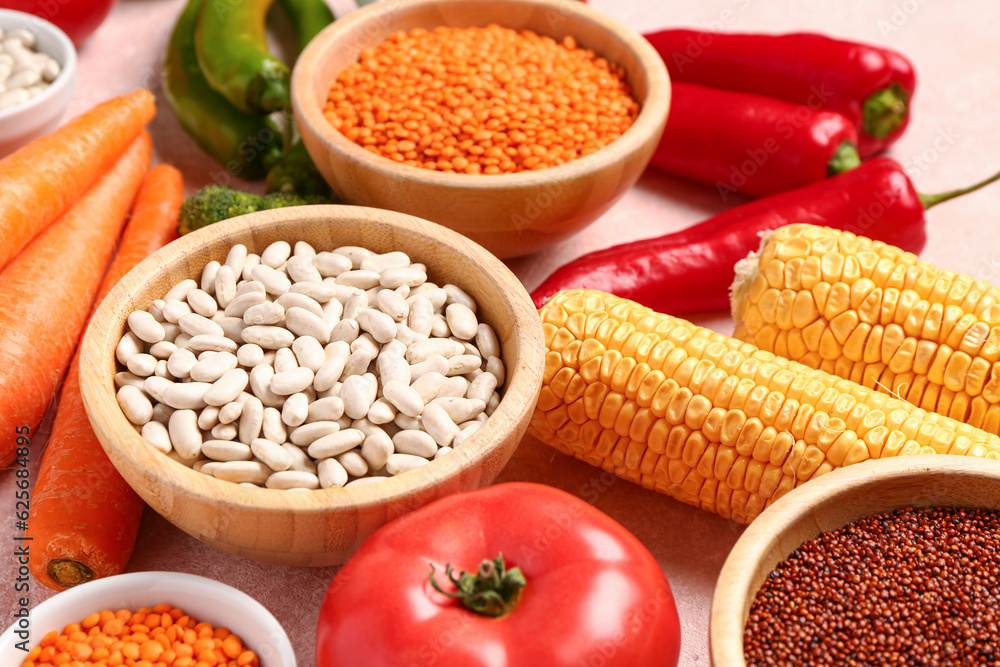 Different fresh vegetables and cereals on pink background, closeup