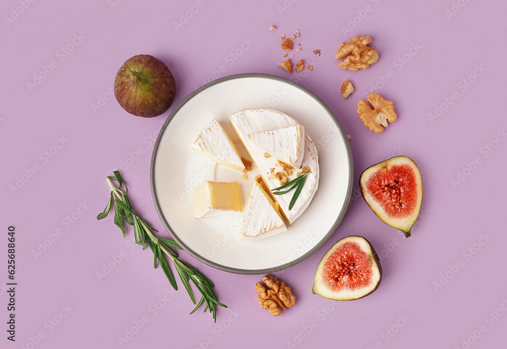 Plate with pieces of tasty Camembert cheese on lilac background