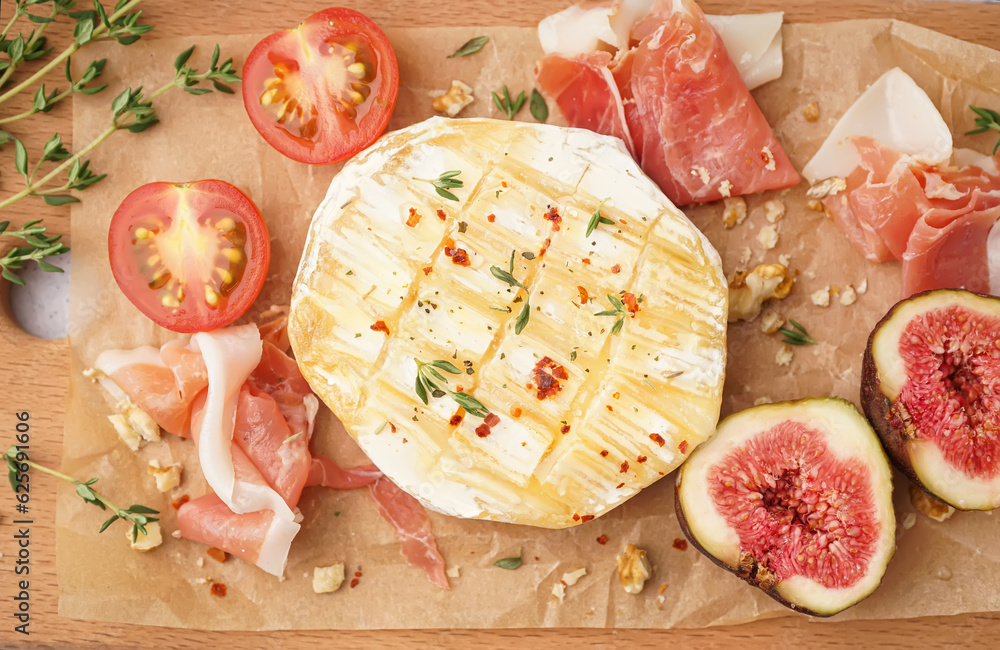 Tasty baked Camembert cheese on table