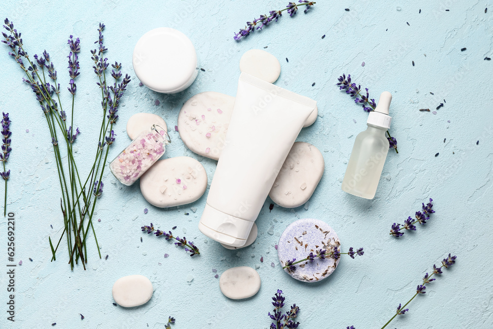 Composition with cosmetic products, spa stones and lavender flowers on color background