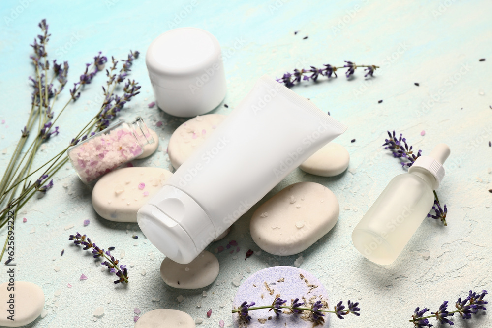 Composition with cosmetic products, spa stones and lavender flowers on color background