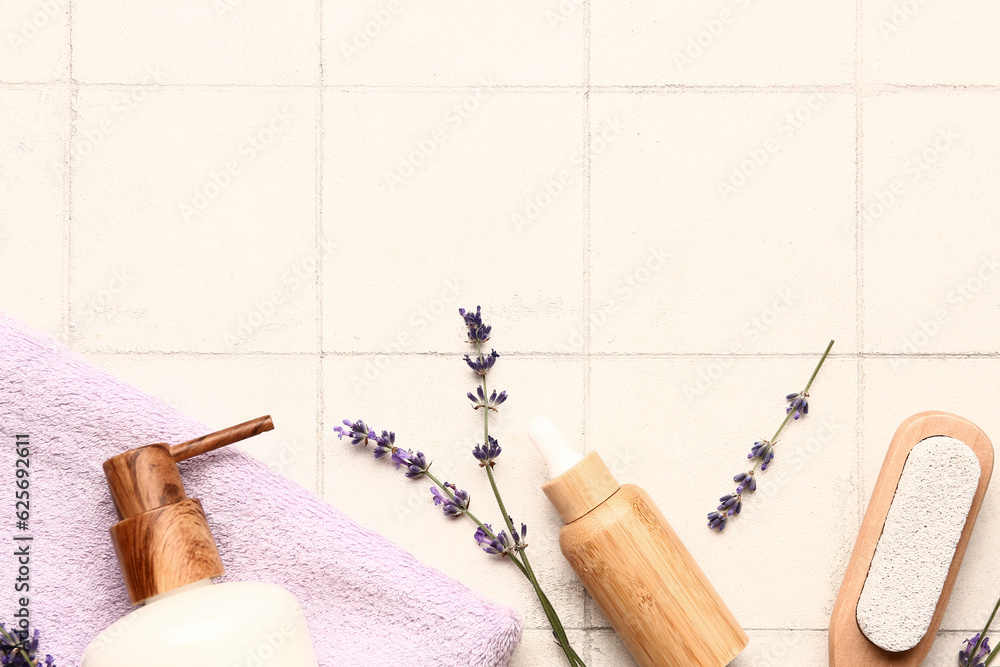 Composition with cosmetic products, bath supplies and lavender flowers on light tile background