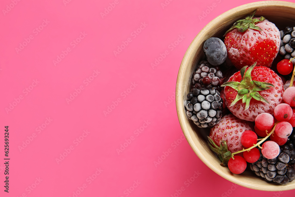 Bowl of frozen berries on pink background