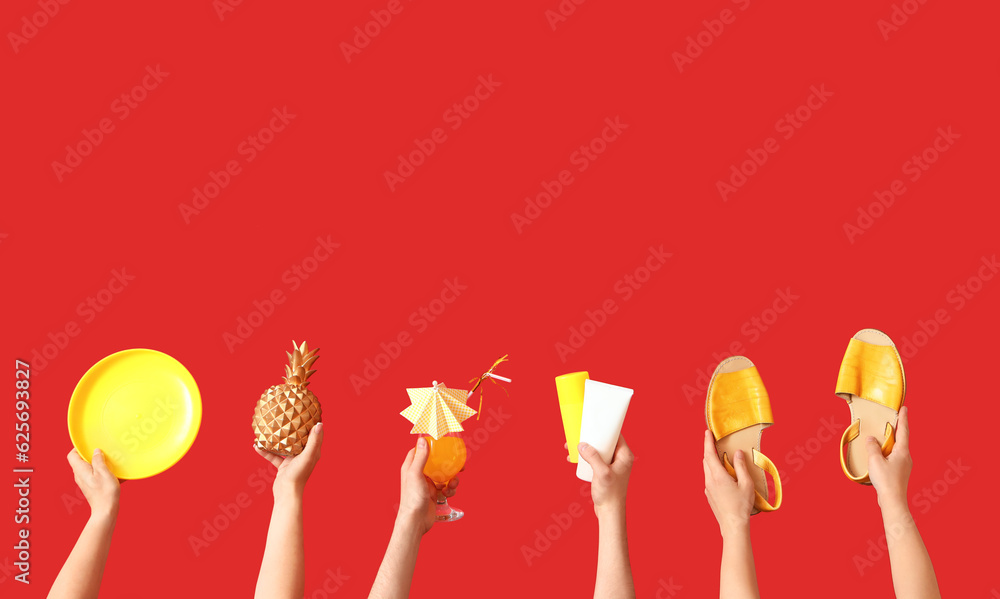 Many hands with cocktail and beach accessories on red background