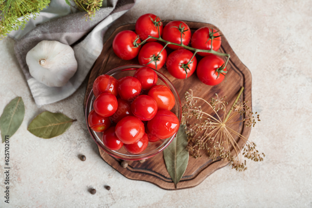 Glass bowl with canned tomatoes and garlic on white background