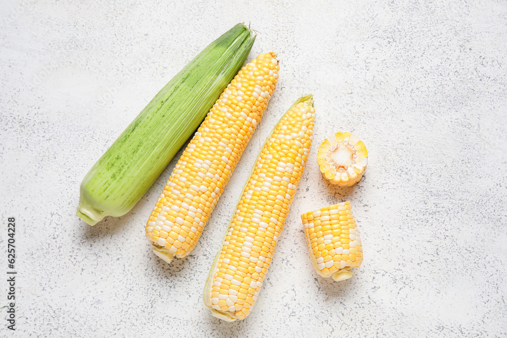 Fresh corn cobs on light background