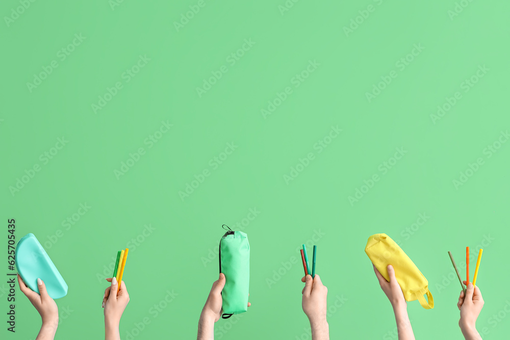 Hands with school accessories on green background