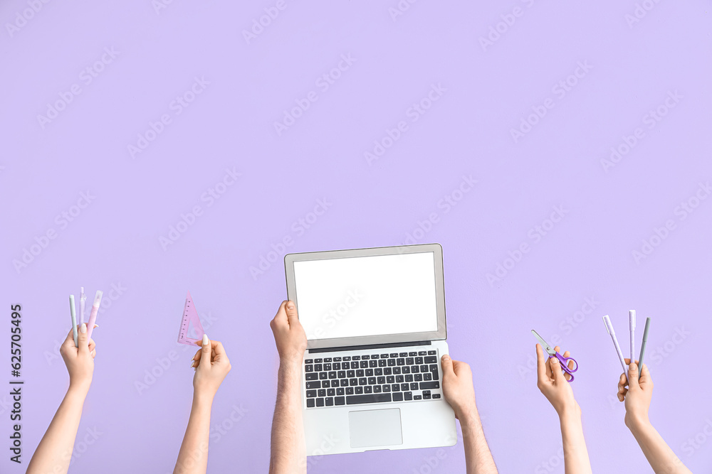 Hands with modern laptop and school supplies on lilac background