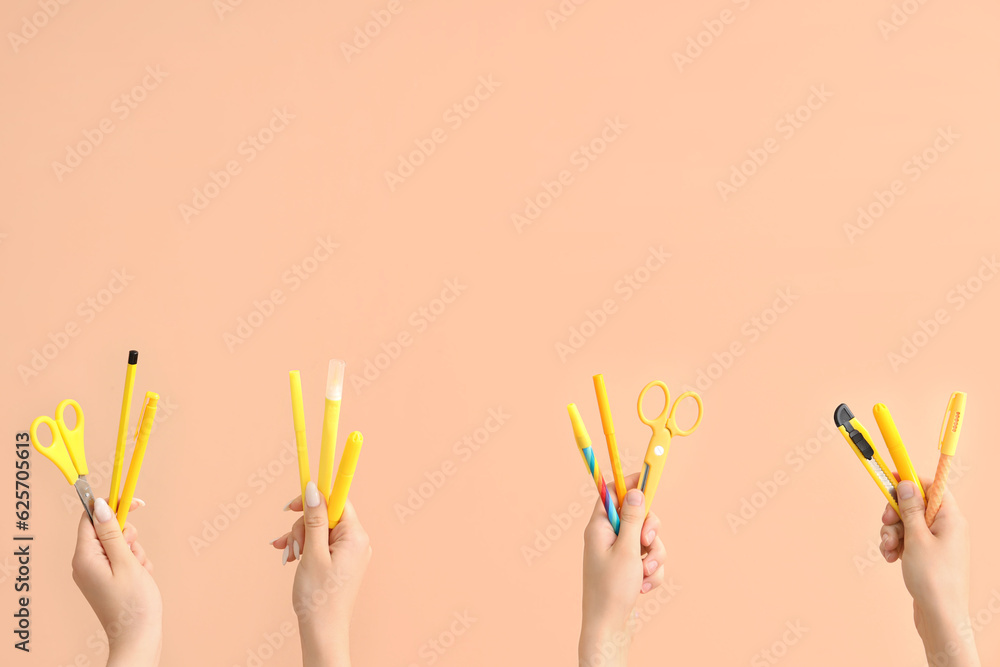 Female hands with school supplies on beige background