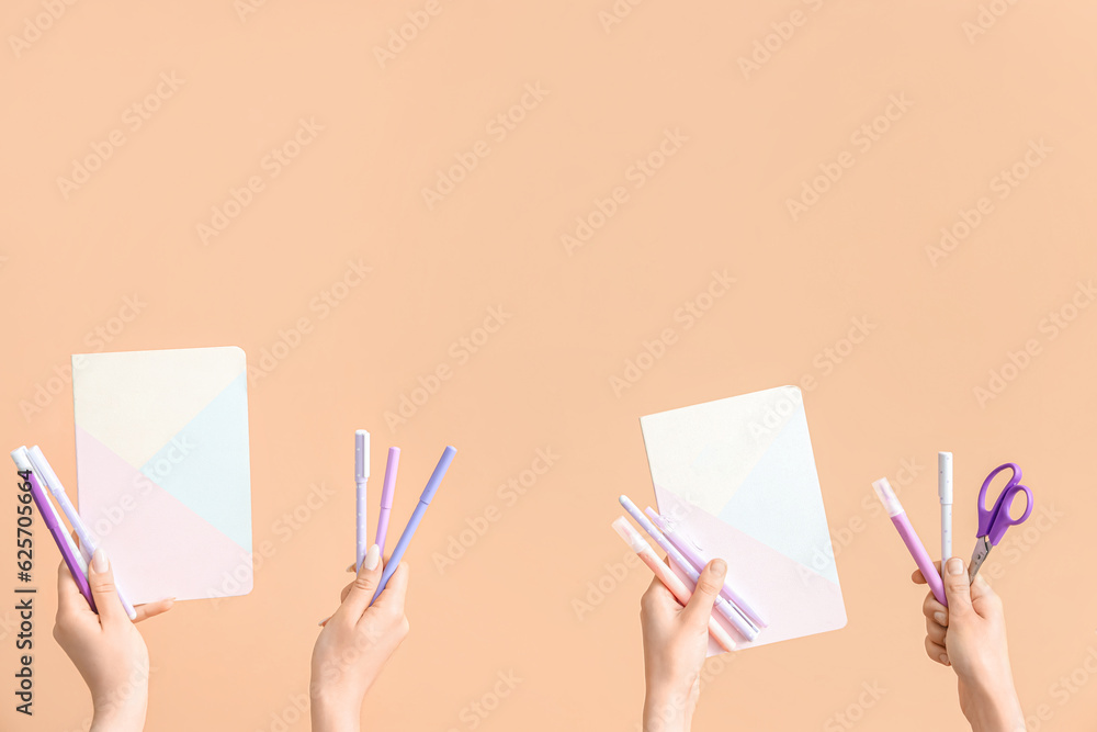 Female hands with school supplies on beige background