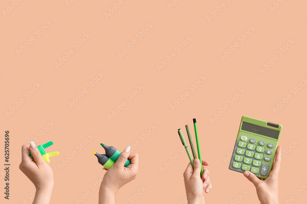 Female hands with school supplies on beige background