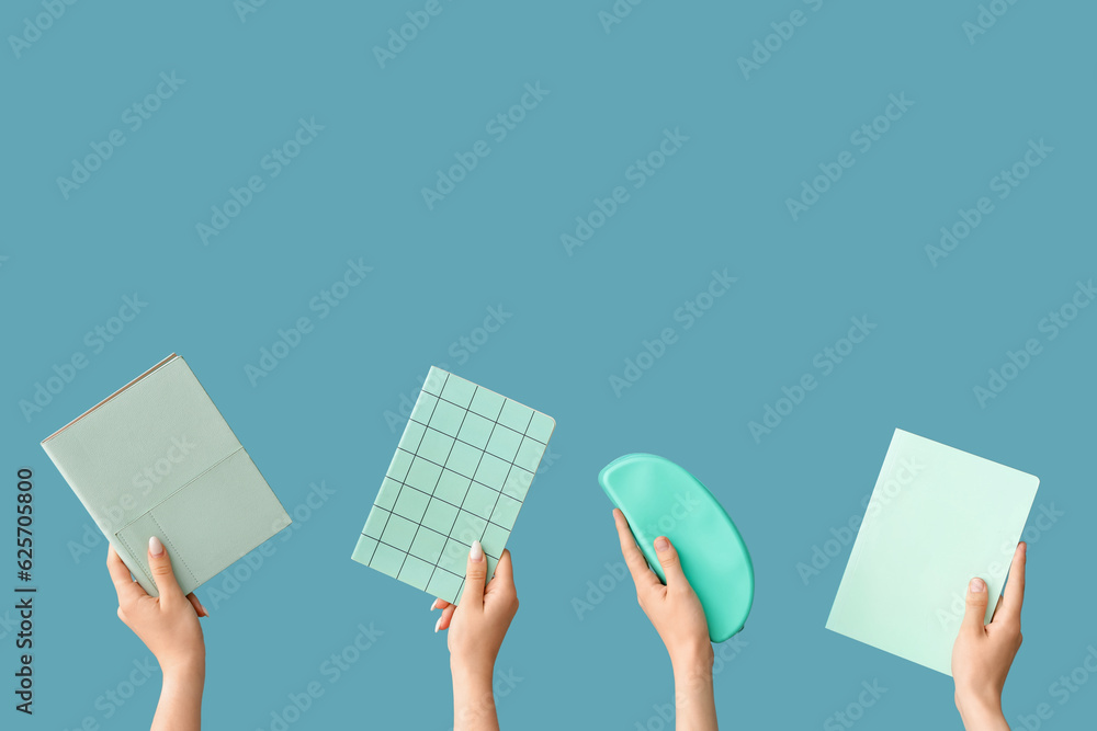 Female hands with school supplies on blue background