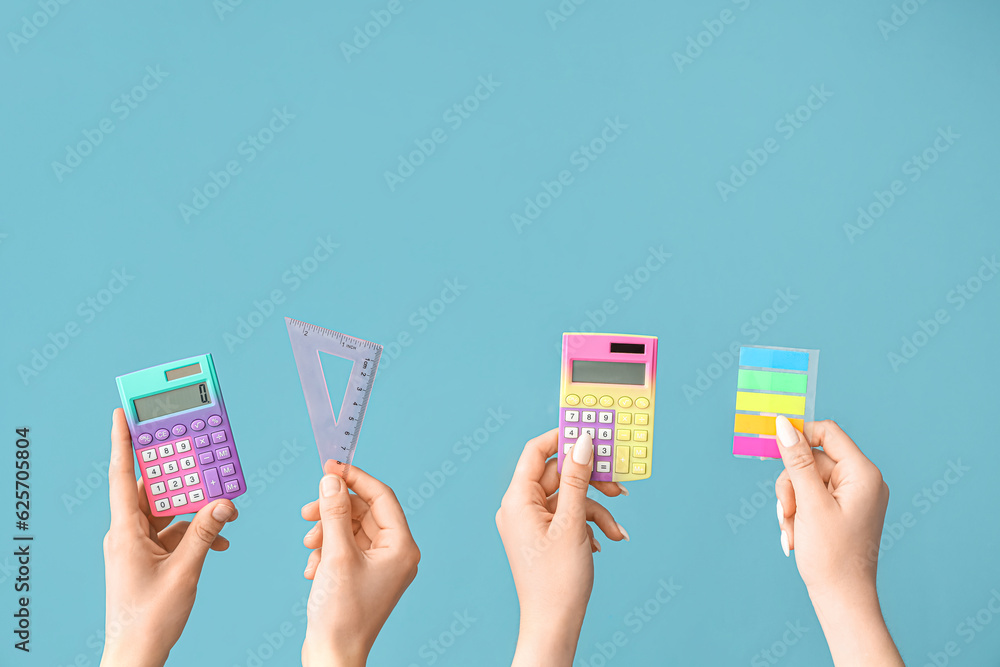 Female hands with school supplies on blue background