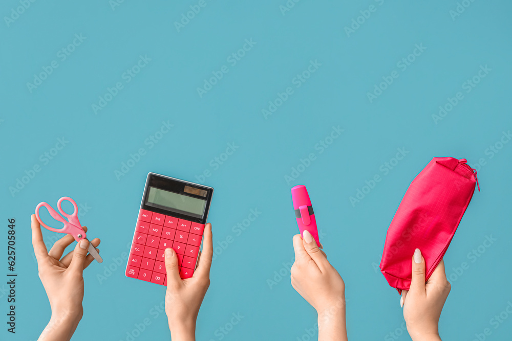 Female hands with school supplies on blue background