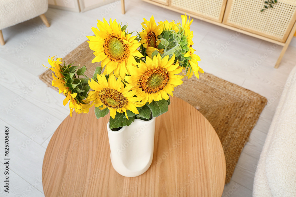 Vase with sunflowers on table in living room, closeup