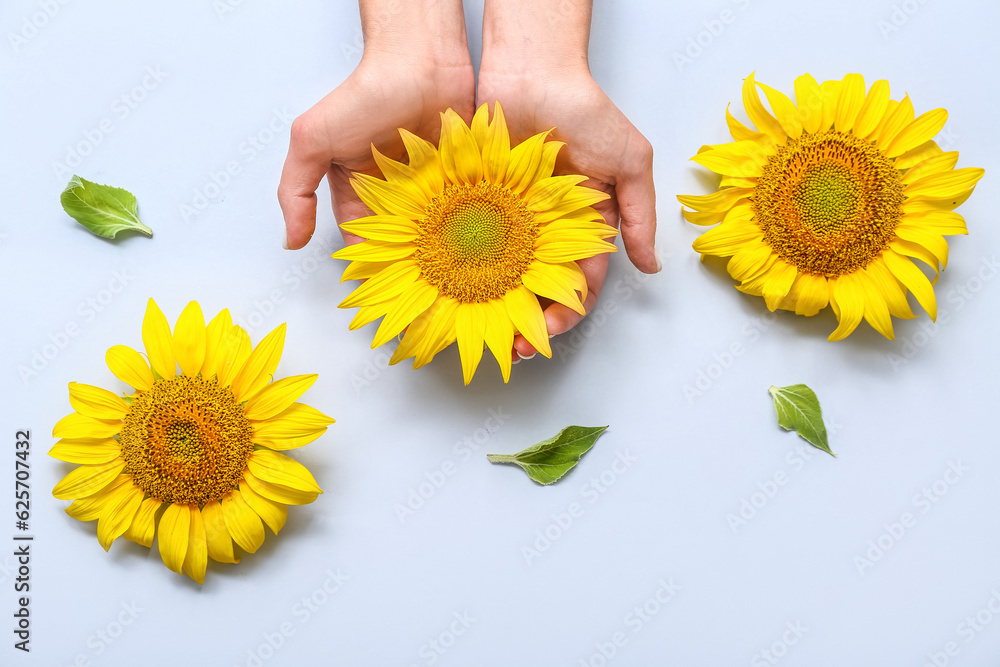 Woman with sunflowers on light background