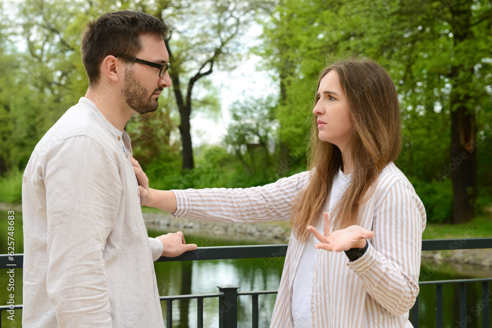 Beautiful couple arguing on bridge in park