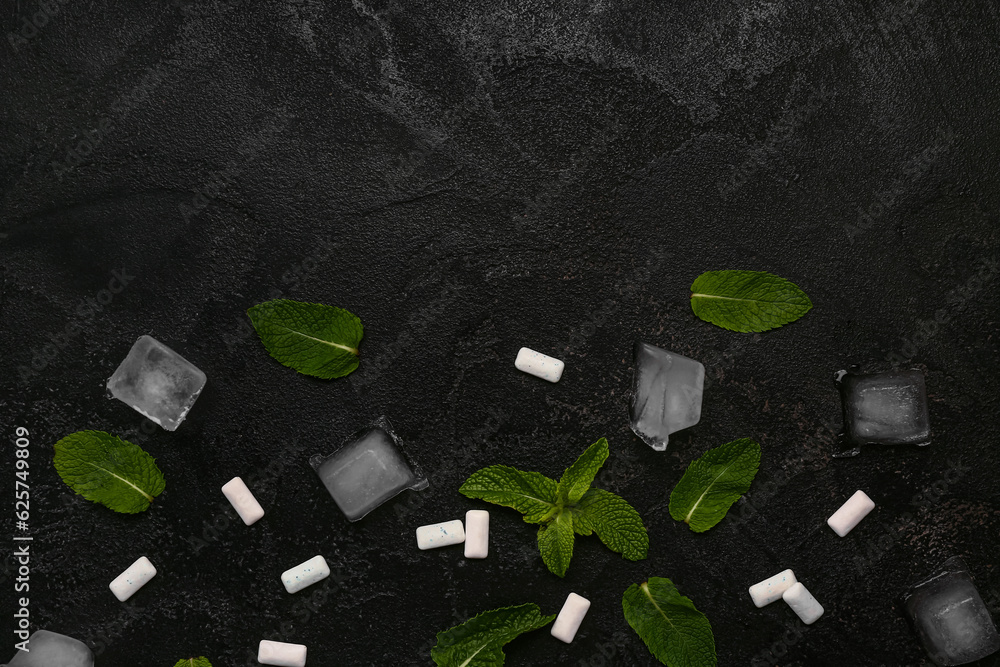 Fresh chewing gums with mint and ice cubes on black background