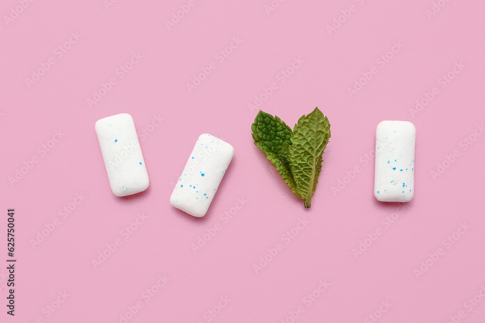 Fresh chewing gums with mint on pink background