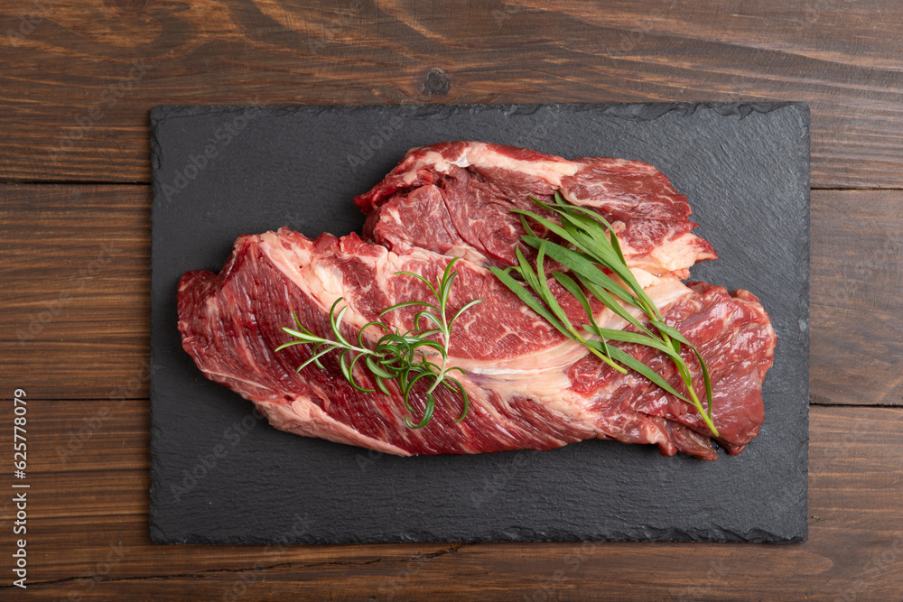 Raw beef steak on wooden table top. Healthy food concept. beef cut and spices for cooking bbq sauce