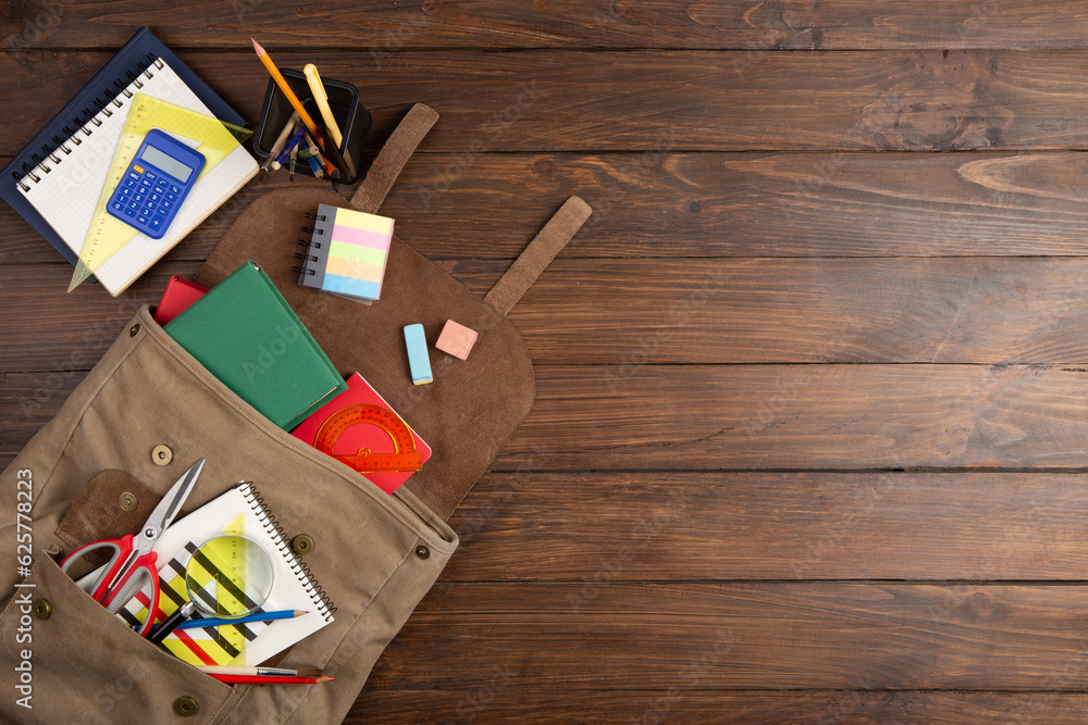 Back to school - books and school backpack on the desk in the auditorium, Education concept.