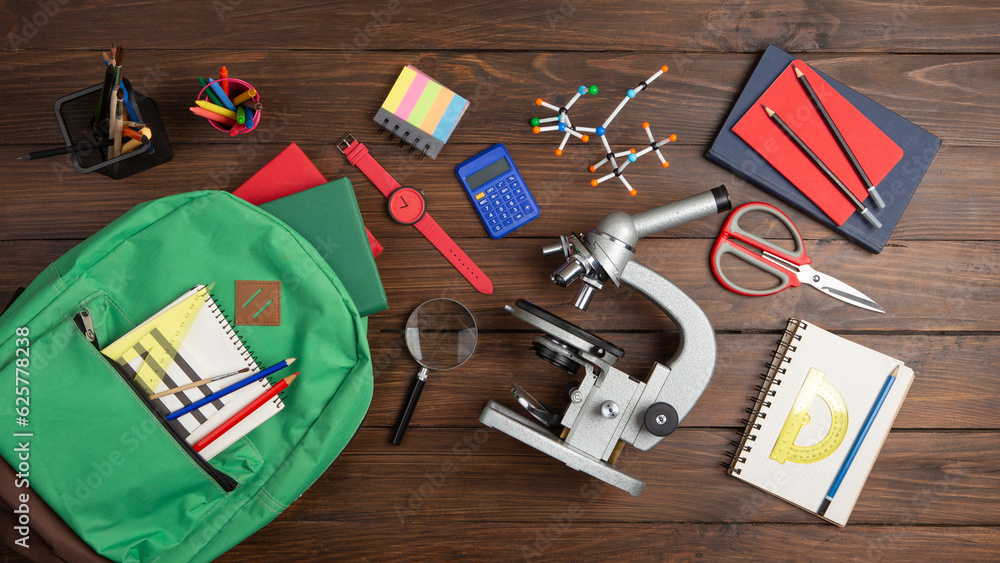 Back to school - books and school backpack on the desk in the auditorium, Education concept.