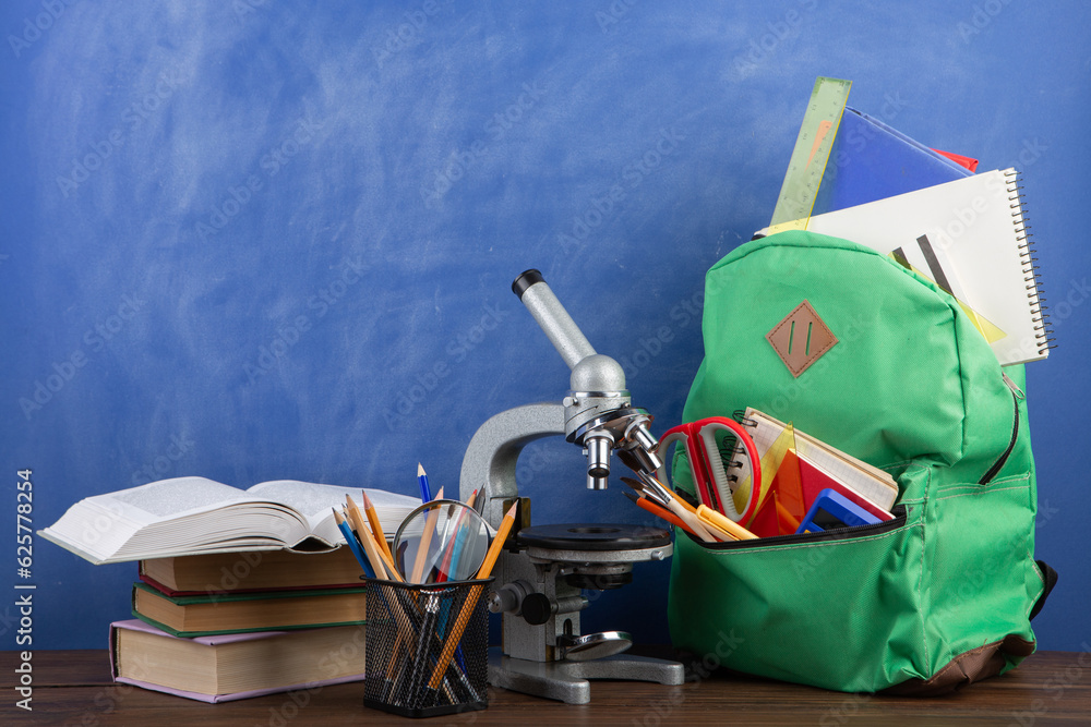 Back to school - books and school backpack on the desk in the auditorium, Education concept.