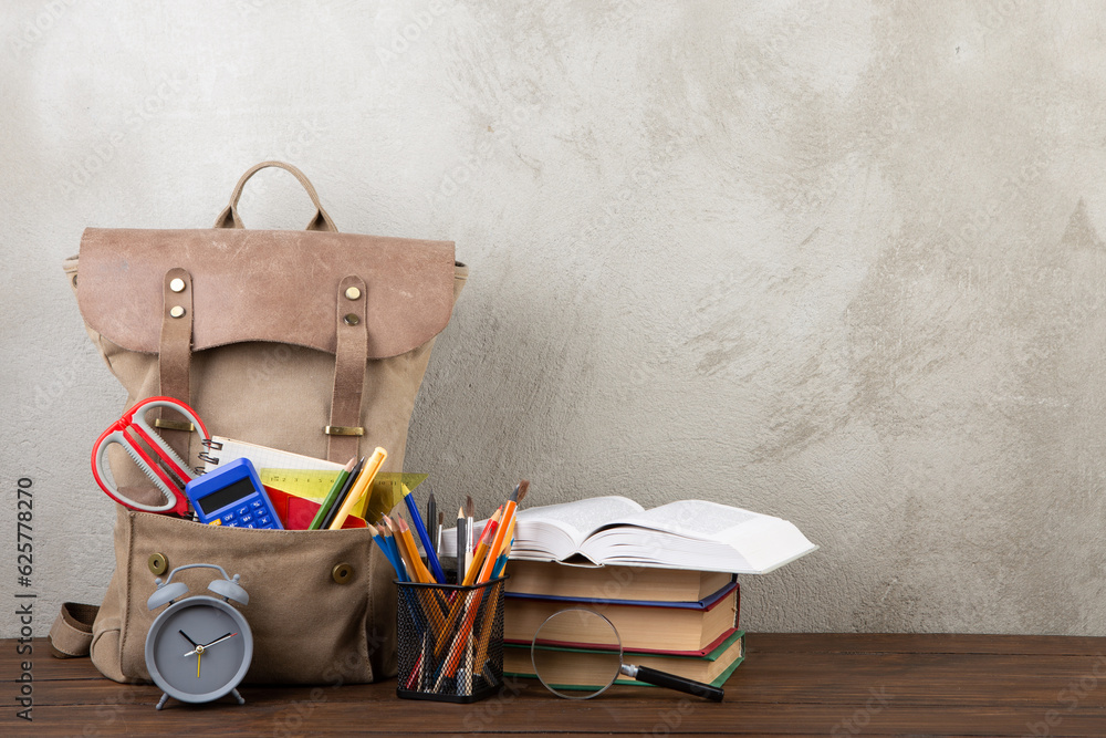 Back to school - books and school backpack on the desk in the auditorium, Education concept.