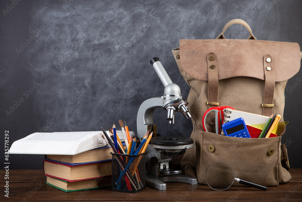 Back to school - books and school backpack on the desk in the auditorium, Education concept.